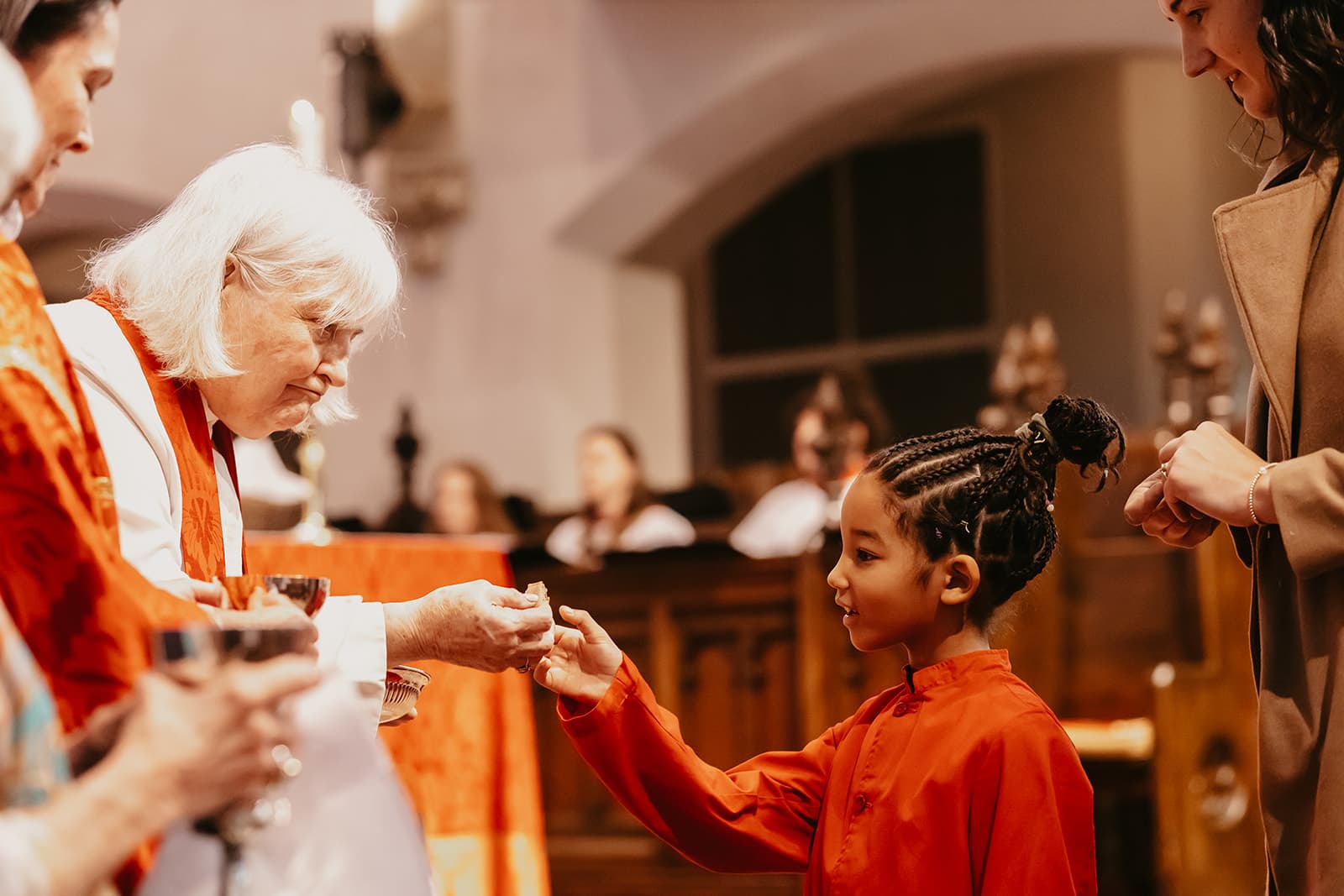 Woman giving communion to a child